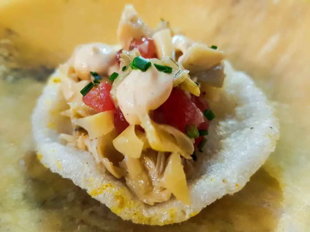 A small tapas: a rice cracker holding a salad inside